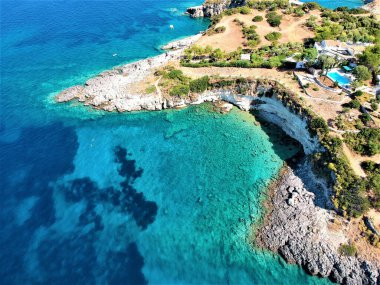 Güzel bir adanın havadan görünüşü ve yaz boyunca açık mavi deniz.