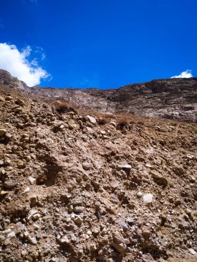 Mavi arkaplanı olan kayalık bir dağın güzel manzarası