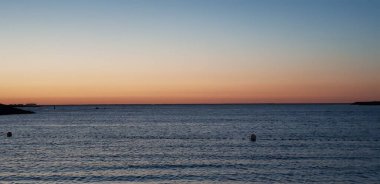 a panoramic shot of sea under sunset