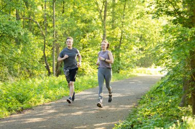 Kafkasyalı iki genç erkek ve dişi ormanda koşuyorlar.