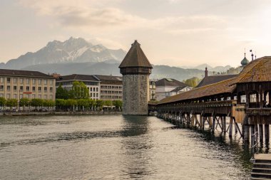 A closeup of a bridge near a tower on the lake
