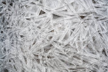 Donmuş bir gölün yüzeyindeki kaya ve buz manzarası.