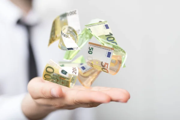 A 3D render of banking euro banknotes in hand rain with blurred male hand