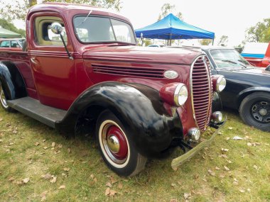 Eski kırmızı ve siyah kamyonet Ford 85 V8 1938 - 1939 kırsal kesimde. Doğa çimenleri ve ağaçlar. Klasik araba şovu..