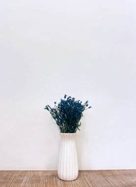 Beyaz seramik minimalist bir kapta güzel mavi çiçekler