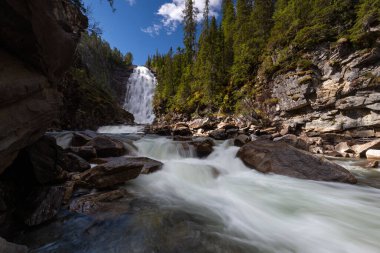 Yazın Tydal dağlarında Henfallet şelalesi. Norveç 'in sıkıcı ormanları arasında büyük ve yüksek düşüşler.