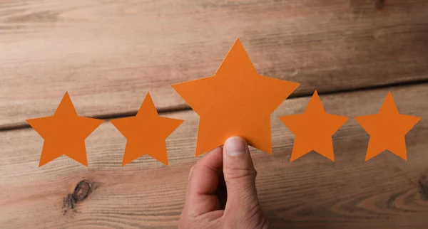 Male Hand Holding Orange Star Rendering Stars Both Sides Wooden —  Fotos de Stock