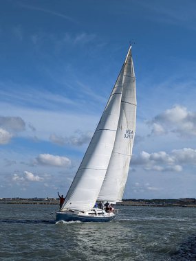 A vertical shot of a yacht in the Corpus Christi bay against a cloudy sky