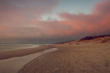 Baltık Denizi kıyısında gün batımının büyüleyici bir görüntüsü.