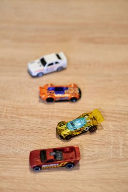 Mattel Hot Wheels 'in tahta yüzeydeki oyuncak arabalarının dikey yakın çekimi..