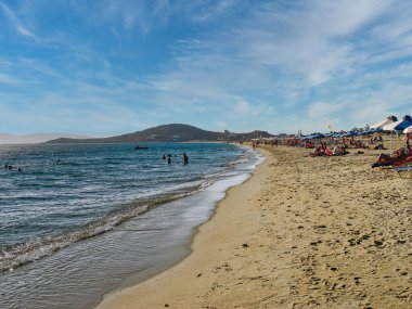 Naxos Adası, Yunanistan. 3 Nisan 2010: İnsanlar Yunanistan 'ın Naxos adasındaki Agios Prokopios plajında denizde yüzerken güneşli havanın tadını çıkarıyorlar 