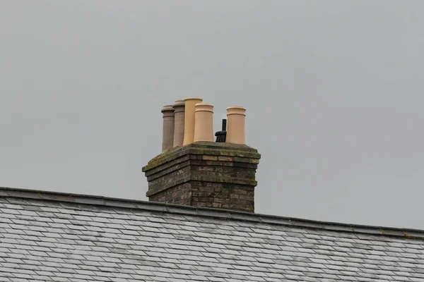 Brick Stack Met Verschillende Soorten Schoorsteenpotten Samen Nat Dak Tegen — Stockfoto