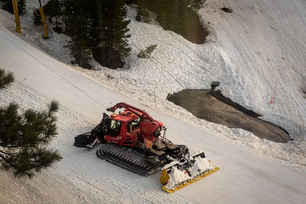 在加利福尼亚州内华达山脉的一辆绞车的帮助下 一只雪猫正在修整陡峭的斜坡 — 图库照片