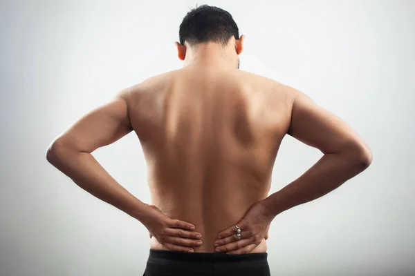 白人の背景で腰痛を患っている若い白人男性 — ストック写真