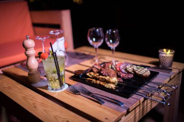 Bir tabak tavuk ve sığır barbeküsü yanında da bir bardak taze mojito.