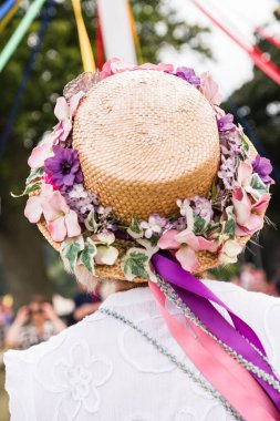 Renkli şapkalı geleneksel bir İngiliz Maypole dansçısının dikey çekimi.