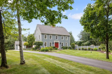 Güneşli bir günde ağaçlarla ve yeşil tarlalarla dolu eski bir kale.