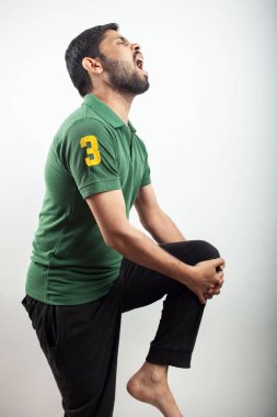 Man holding his knee suffering from knee joint inflammation with Shouting expression.