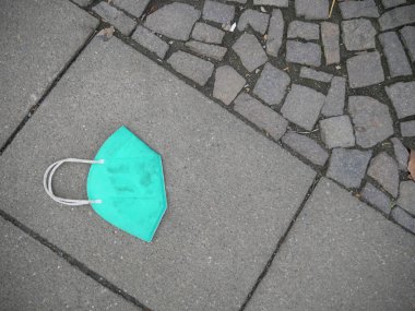 dirty azure corona mask on the pavement