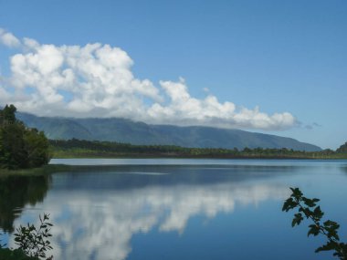 Şili 'deki Pumalin Ulusal Parkı' ndaki suya yansıyan sakin bir gökyüzü manzarası