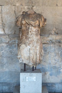 A vertical shot of an Athens headless sculpture in front of a building