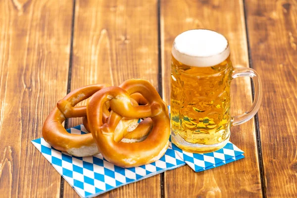 A pretzel and beer for german Oktoberfest on a wooden table