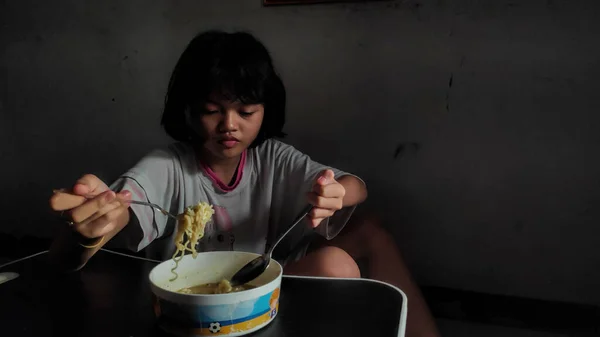 可愛いですアジアの子供の女の子食べるためにインスタントラーメンのために彼女の食事で朝 — ストック写真