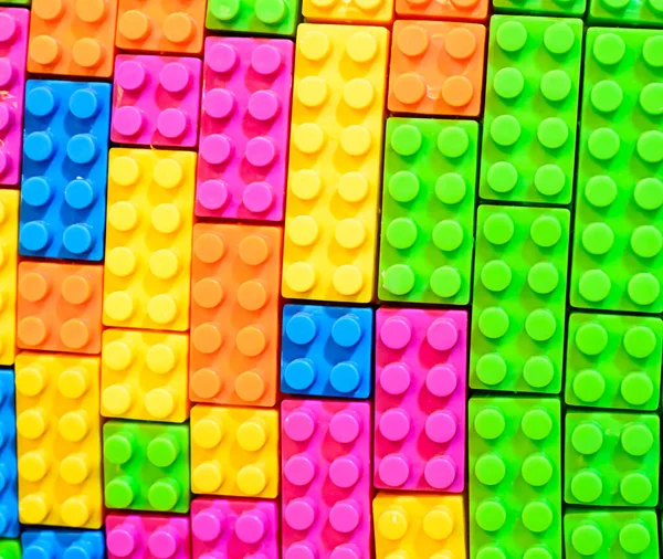 A closeup shot of a shape been arranged with colorful pieces of plastic Lego