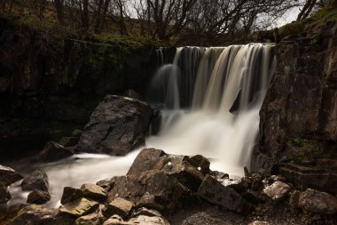 A beautiful waterfall in the forest in Ireland in autumn