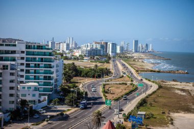 Deniz kenti boyunca giden bir otoyolun havadan çekilmiş görüntüsü.