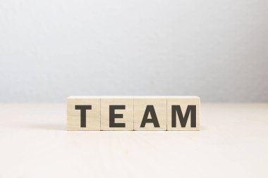 A closeup of wooden blocks with a word TEAM on a white table