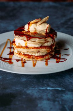 Kremalı ve muzlu beyaz tabakta dikey krep.