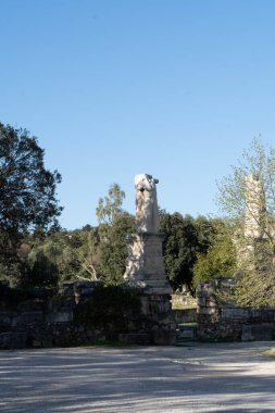 Atina parkında kafası olmayan bir adamın heykelinin dikey görüntüsü.