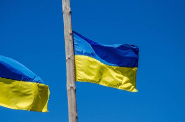 The state flag of Ukraine on a background of blue sky