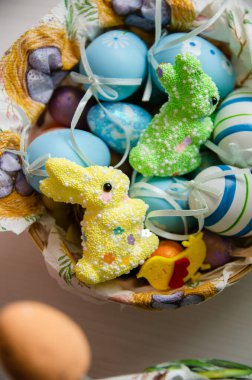 Vertical closeup shot of blue and white foam eggs and bunny decorations in a basket for Easter