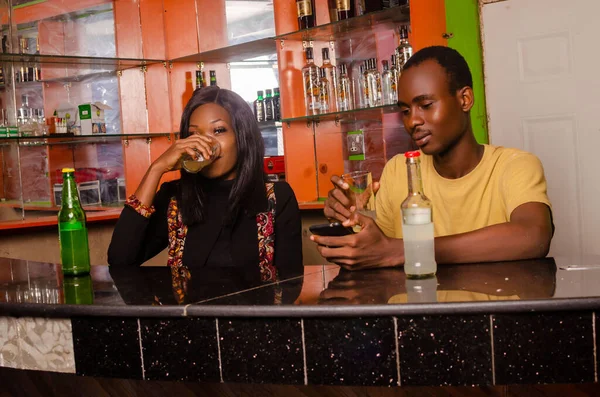 Молодая Нигерийская Пара Сидит Баре Выпивает Глядя Телефону — стоковое фото