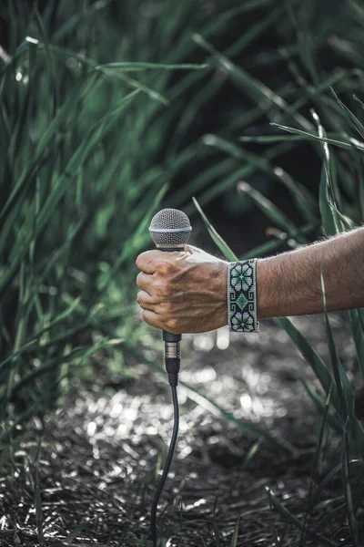 Una Mano Sosteniendo Micrófono Con Bosque Fondo — Foto de Stock