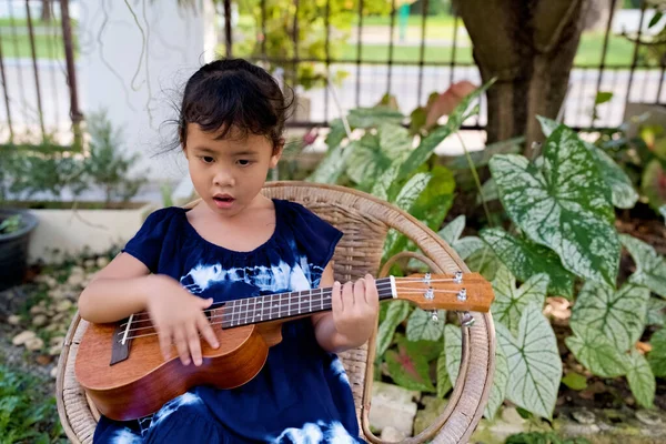 一个东南亚小孩在后院玩四弦琴 — 图库照片