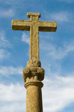 İspanya, Galiçya 'da mavi gökyüzünün altında bir taş haçı.