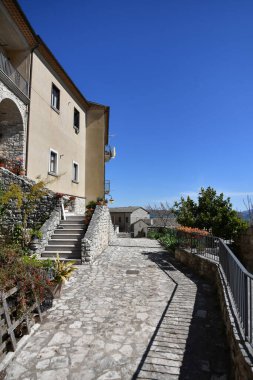 Gesualdo İtalya 'da küçük bir köyde mavi gökyüzünün altında evleri olan dar tuğlalı bir sokak.