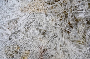 Donmuş bir gölün yüzeyindeki kaya ve buz manzarası.