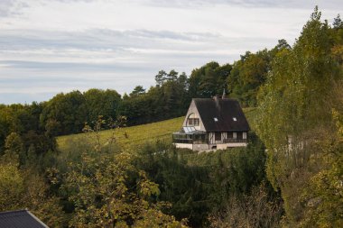 A small house in the middle of vineyards on cloudy sky background