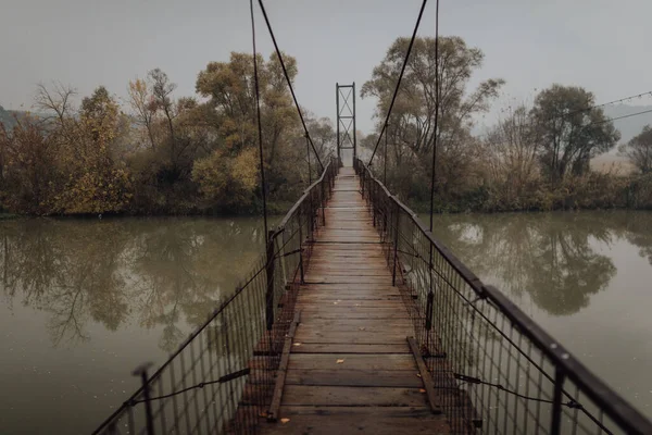 Eerie Scenery Wooden Suspension Bridge River Cloudy Day —  Fotos de Stock