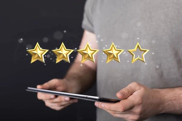 A 3d rendering of a review icon and rating stars showing a feedback above a tablet in a person\'s hands