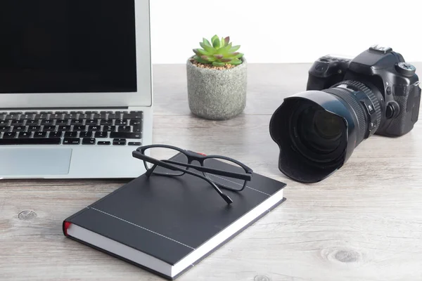 摄影师工作站 带着照相机 笔记本电脑 木制桌子上的眼镜 — 图库照片