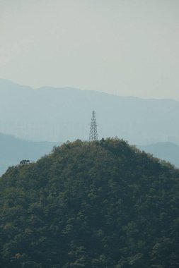 A vertical shot of a transmission tower on Wutong Mountain in Shenzhen, China in blue sky background