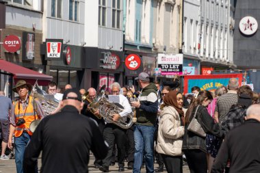 İnsanlar bir Mayıs yürüyüşüne katılıyor, işçi hakları, eşitlik, NHS için kampanya yapıyor ve barış umutlarını paylaşıyor.