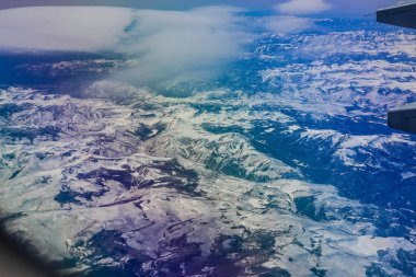 An airplane view to the snowy hills