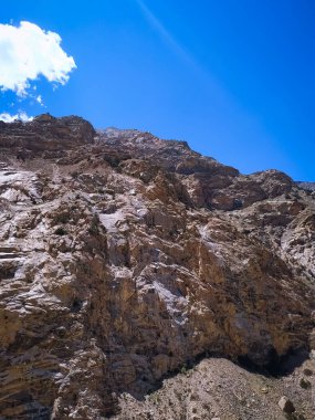 Mavi arkaplanı olan kayalık bir dağın güzel manzarası