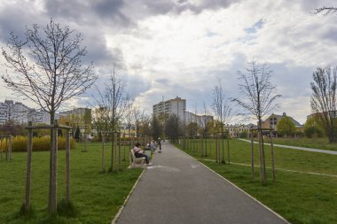 A footpath along grass at a park in the Orla Bialego district on a cloudy day, Poznan, Poland